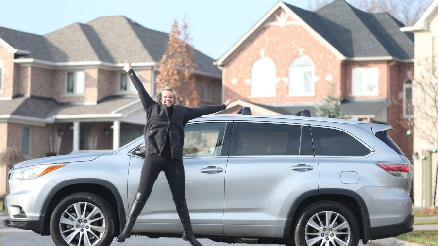 A woman posing in front of her Toyota Highlander