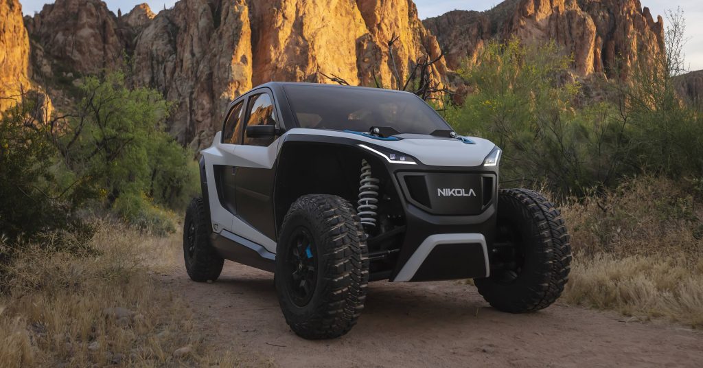 A white and black Nikola NZT ATV/UTV sits on a dirt canyon road.