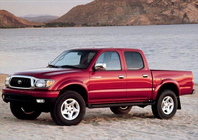 2001 Toyota Tacoma like this red one parked near the shore is the best used pickup truck to buy