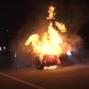 An Audi RS3 in flames on a highway at night.