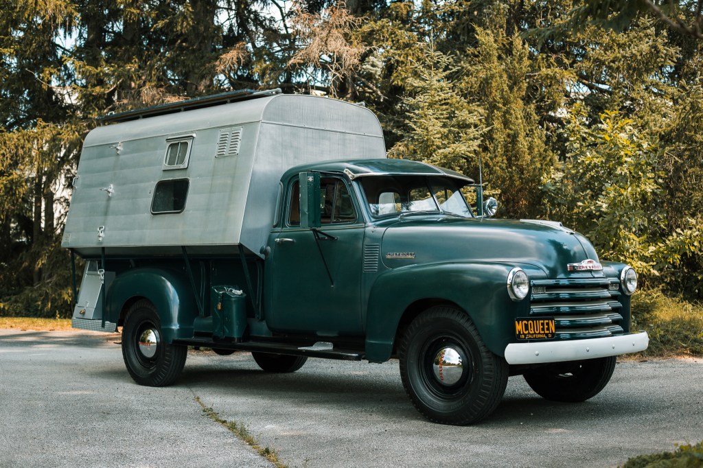 Parked on a driveway is Steve McQueen's Forest Green 1952 Chevrolet 3800 Dust Tite Camper