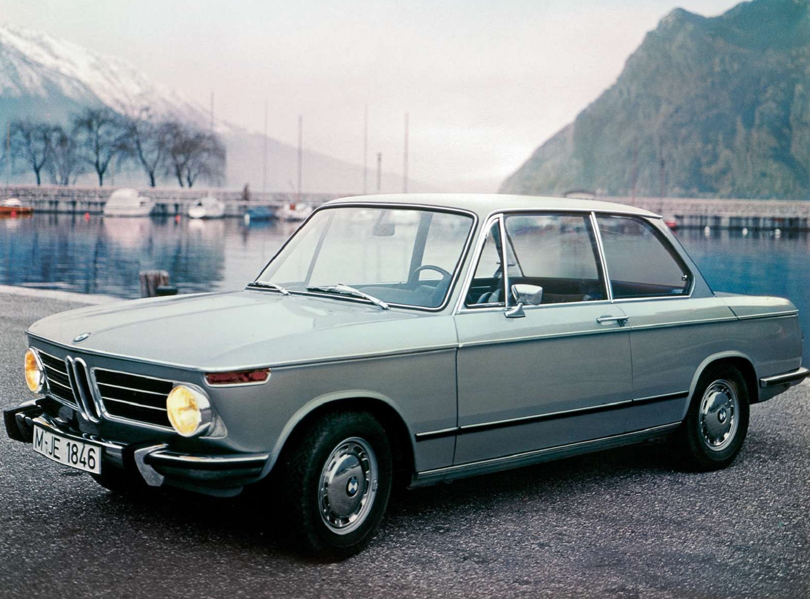 A light-blue 1968 BMW 2002 at a pier