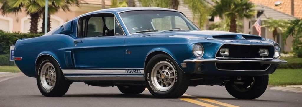 A blue, rare 1968 Shelby Mustang GT500 KR is viewed from the front passenger quarter.