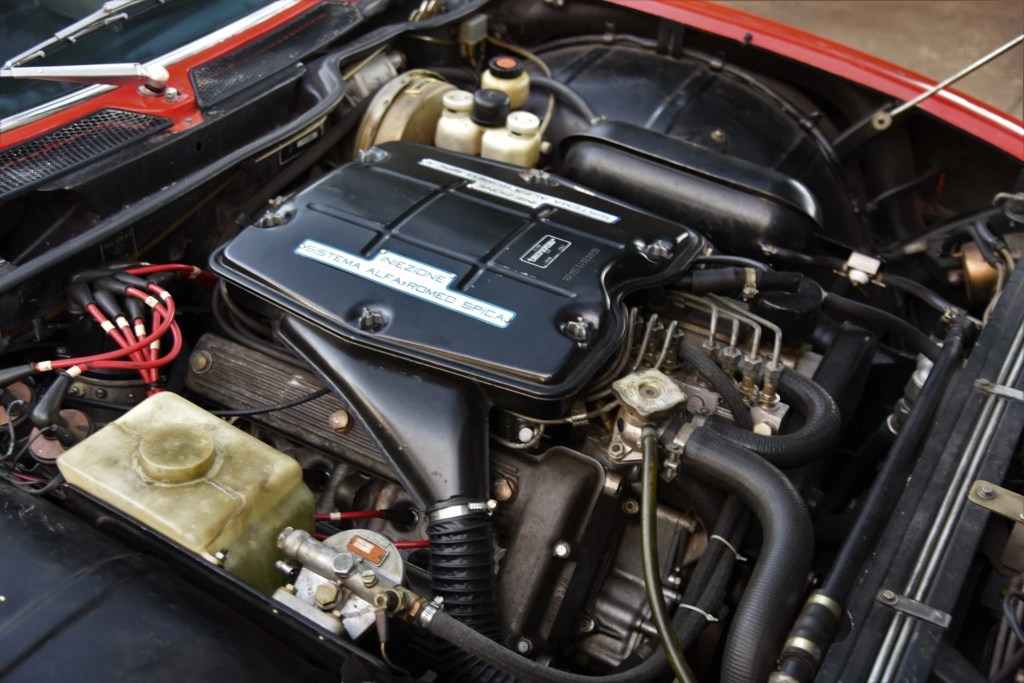 The 1972 Alfa Romeo Montreal's V8 engine with a label indicating its mechanical fuel injection