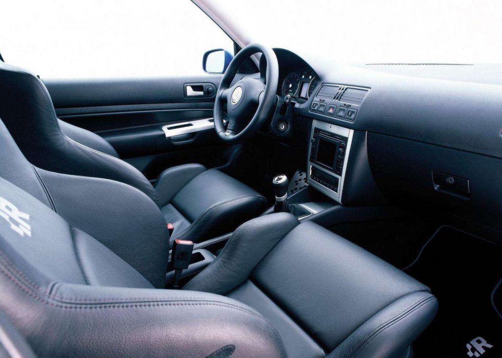 The black interior of a 2004 Volkswagen R32, showing the 6-speed manual and leather Konig sport seats
