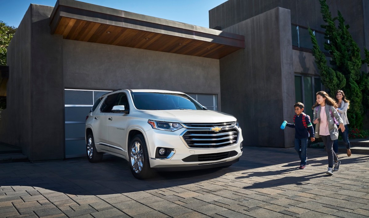 2020 Chevrolet Traverse parked outside a house with a family excited to get into the SUV