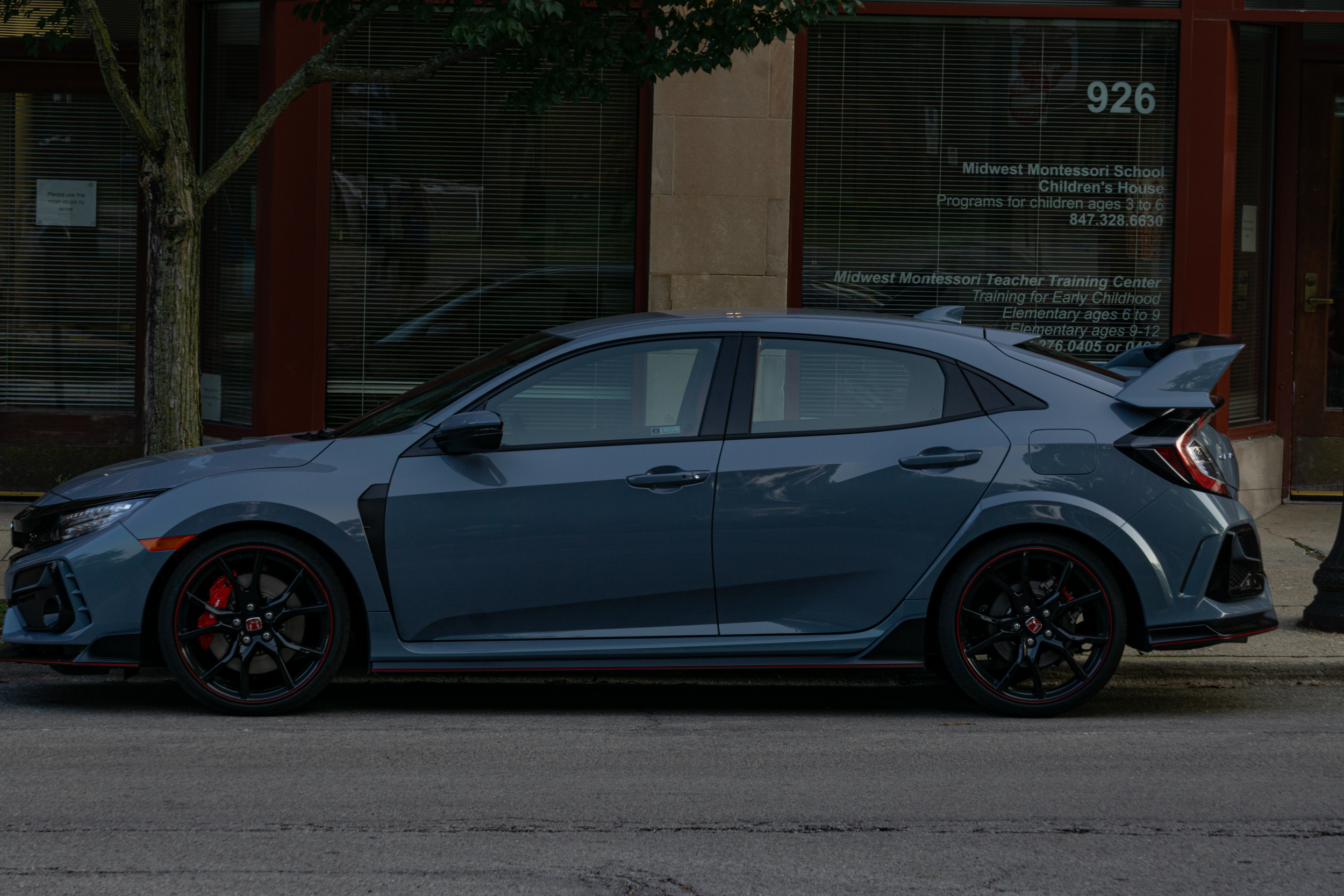 The side view of a gray 2020 Honda Civic Type R on a city street