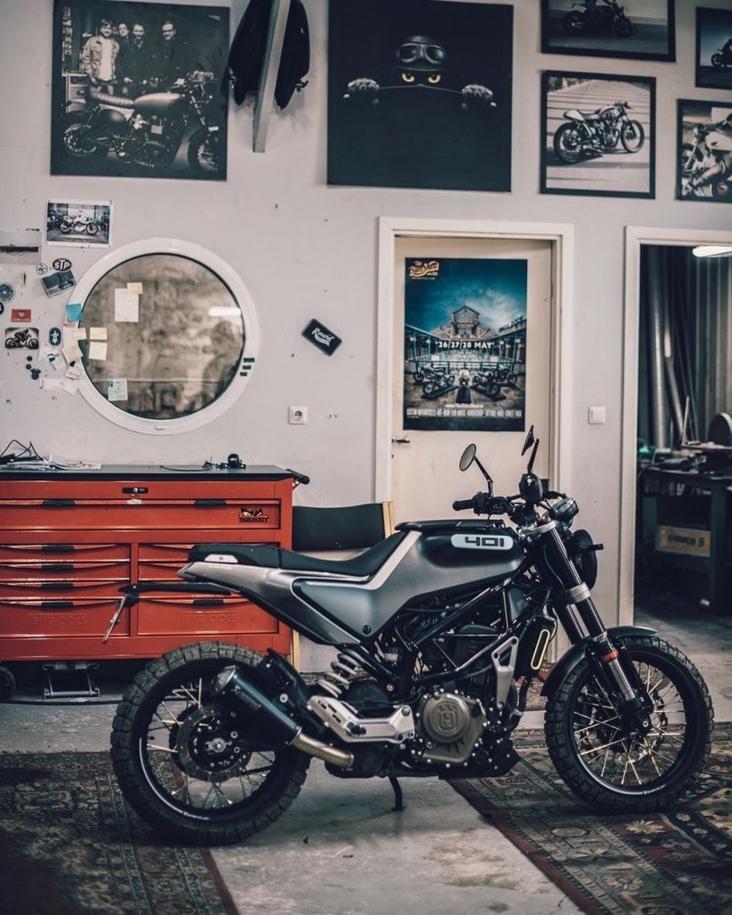 A gray 2020 Husqvarna Svartpilen 401 in front of a wall of posters and photos