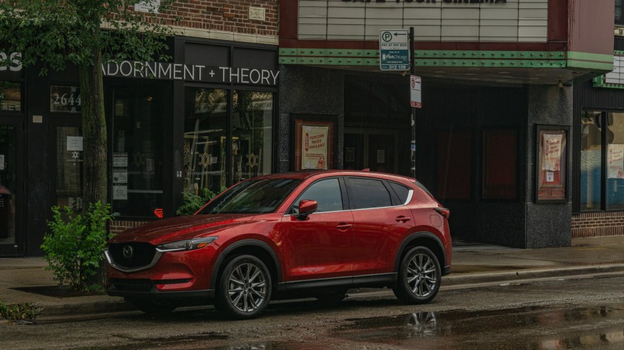 A red 2020 Mazda CX-5 Signature AWD on a rainy city street