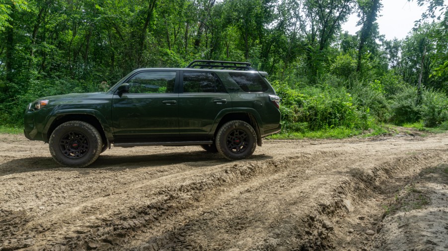 A green 2020 Toyota 4Runner TRD Pro on a rutted muddy forested off-road trail