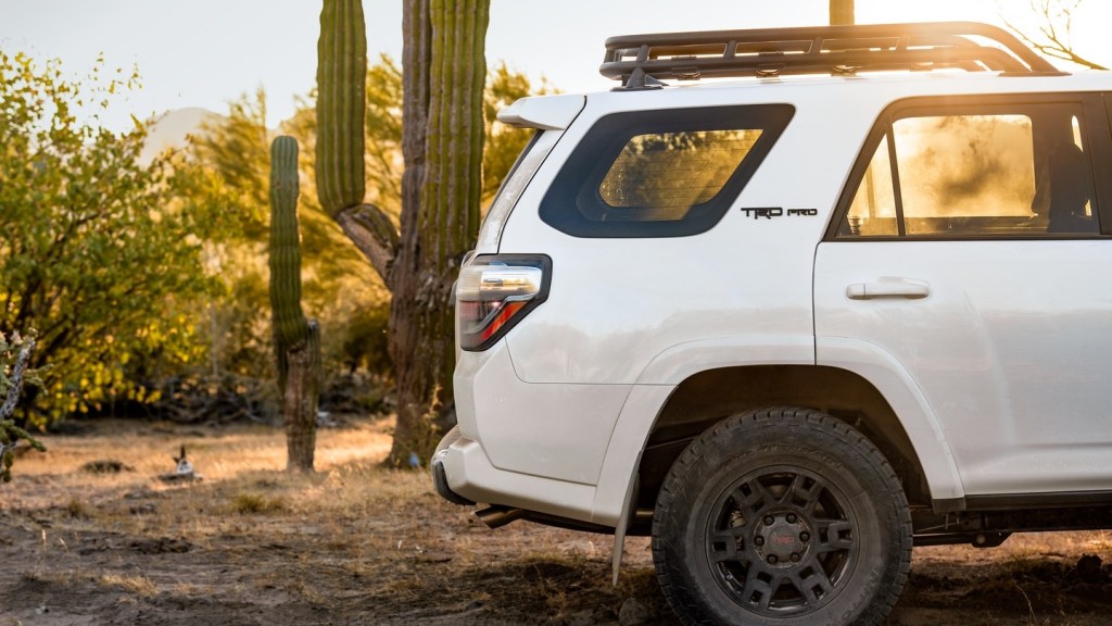 The rear half of a white 2020 Toyota 4Runner TRD Pro in the desert, showing the thick C-pillar and roof rack