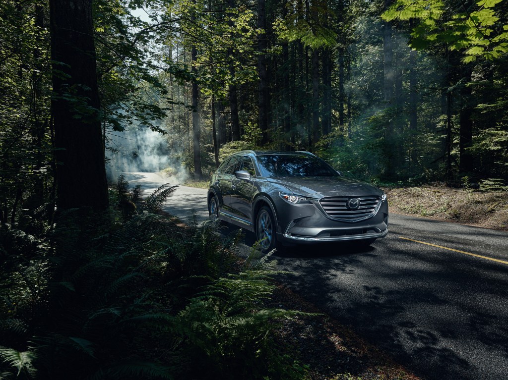 the 2020 Mazda CX-9 driving on a scenic forested back road