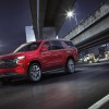 A red 2021 Chevrolet Tahoe drives on a city's highway at night