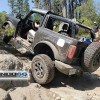 A black 2-door 2021 Ford Bronco with its doors and roof removed scrambles up a rocky incline on the Rubicon Trail