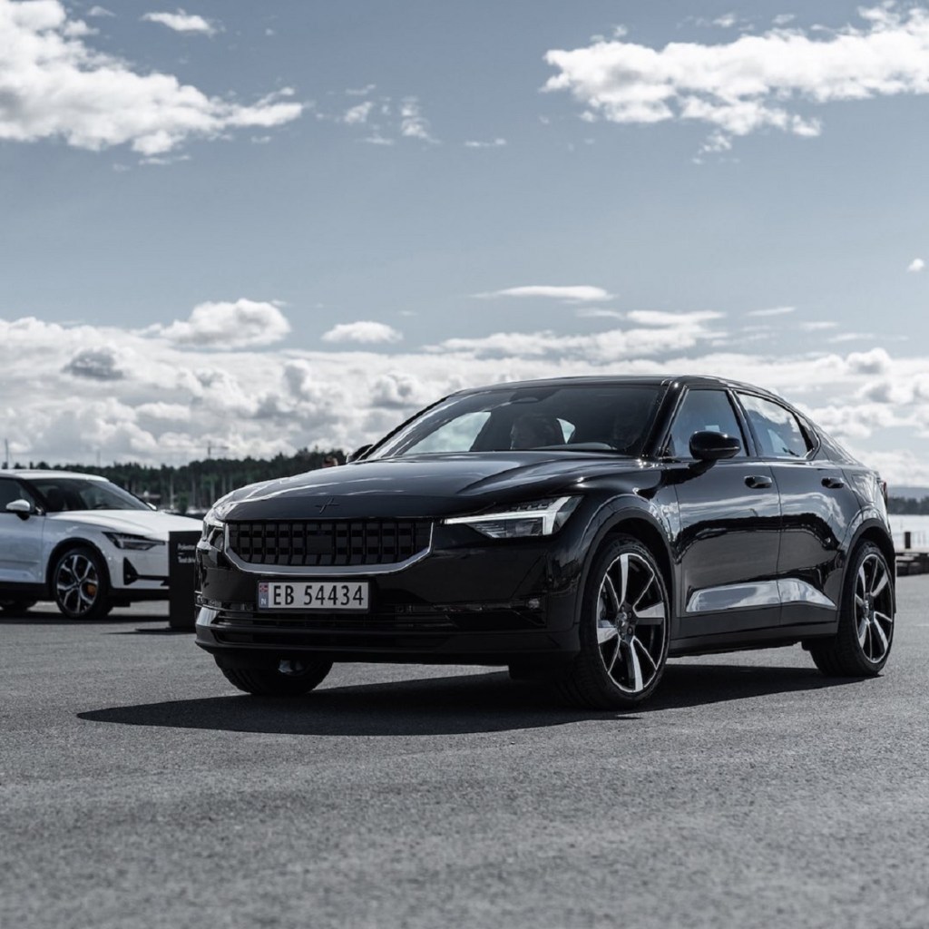 A black 2021 Polestar 2 with a white one in the background