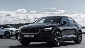 A black 2021 Polestar 2 with a white one in the background