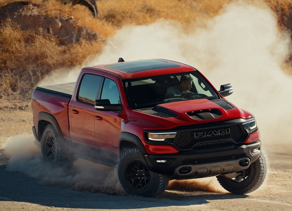 A red 2021 Ram 1500 TRX slides through the desert in a big dust cloud