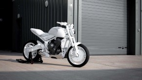 A white 2021 Triumph Trident prototype in front of a garage
