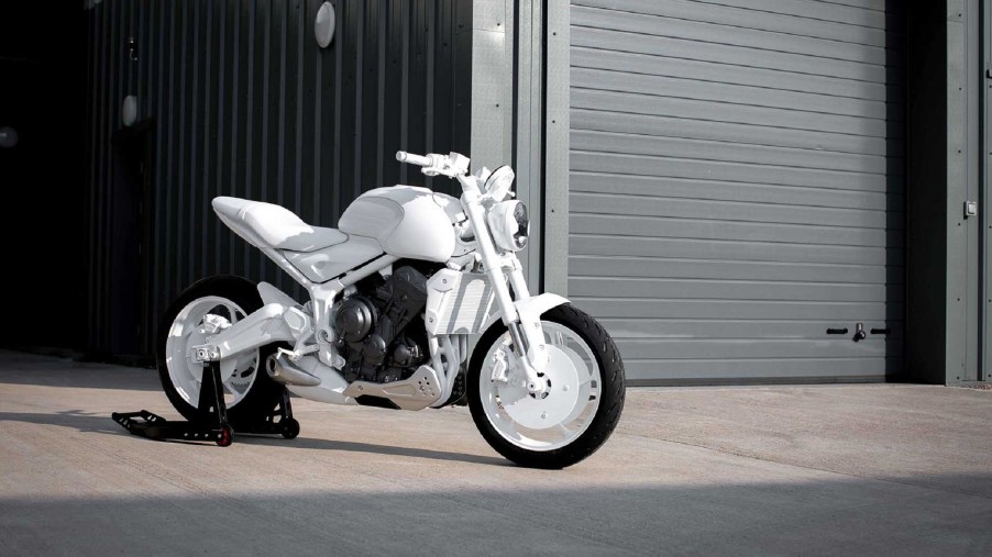 A white 2021 Triumph Trident prototype in front of a garage