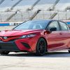 a red Toyota Camry TRD with black exterior detail parked near a race track