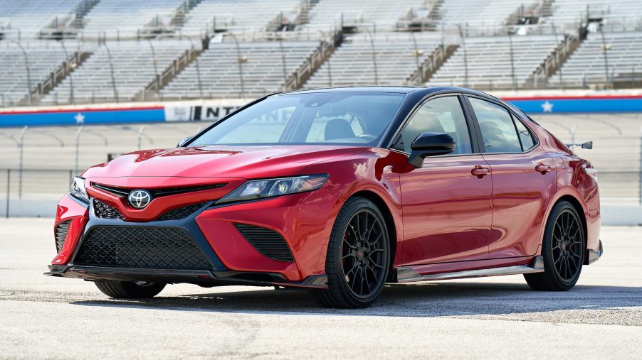 a red Toyota Camry TRD with black exterior detail parked near a race track