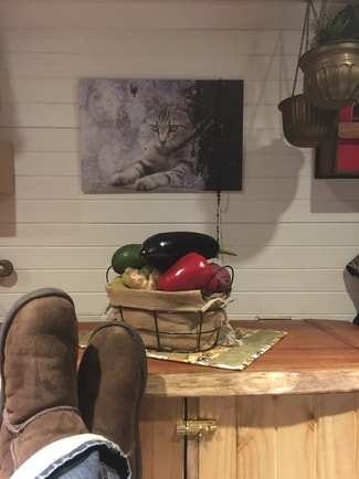 a lovely still life arrangement of peppers with the view of brown boots resting in a relaxed pose inside of the camper