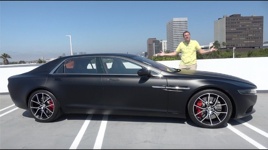 Doug Demuro with a matte-black Aston Martin Lagonda Taraf on the roof of a city parking garage
