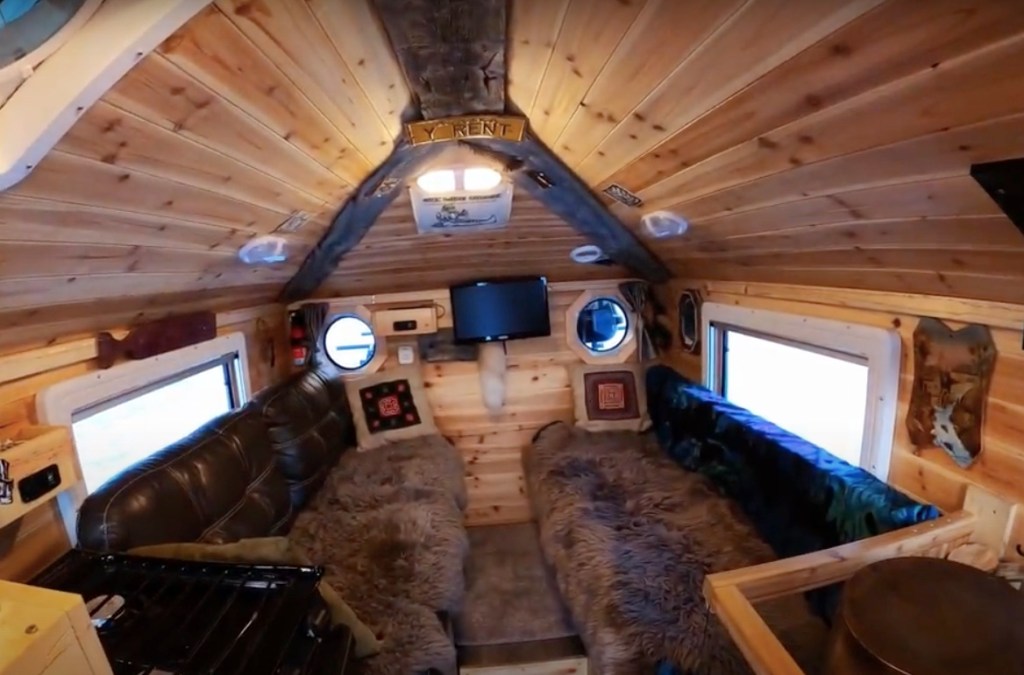 the wooden interior of the roomy hangout space inside of the Alaskan overland RV cabin