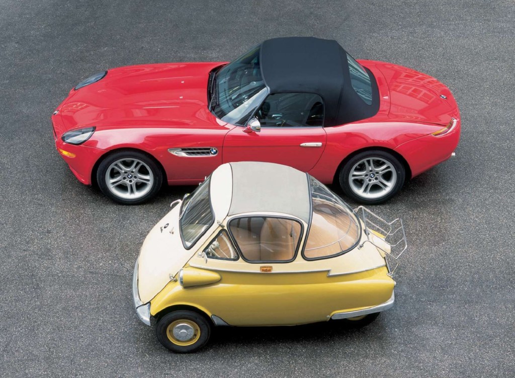 A red BMW Z8 convertible parked next to a yellow-and-tan BMW Isetta