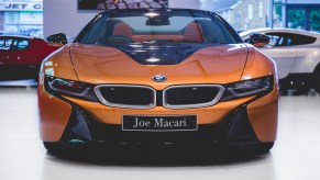 The BMW i8 in the Joe Macari Performance Cars Showroom. The BMW i8 was designed by Benoit Jacob and the production model was unveiled at the 2013 International Motor Show in Germany. It features butterfly doors, head-up display, rear-view cameras and partially false engine noise