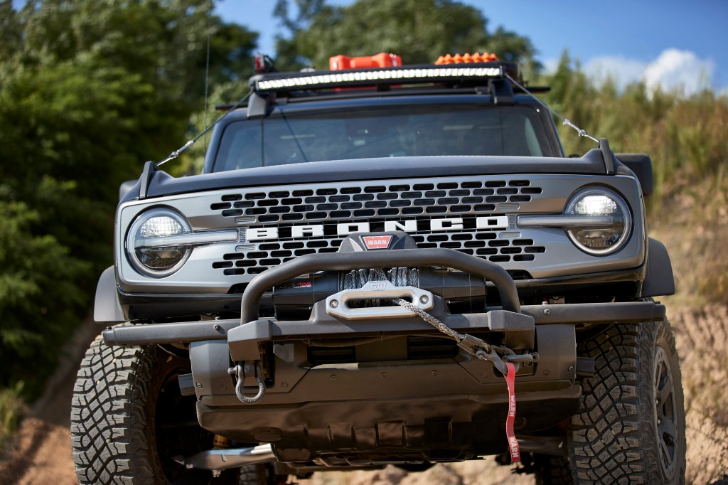 A head-n view of a black 2021 Ford Bronco with a aftermarket bumper and winch.