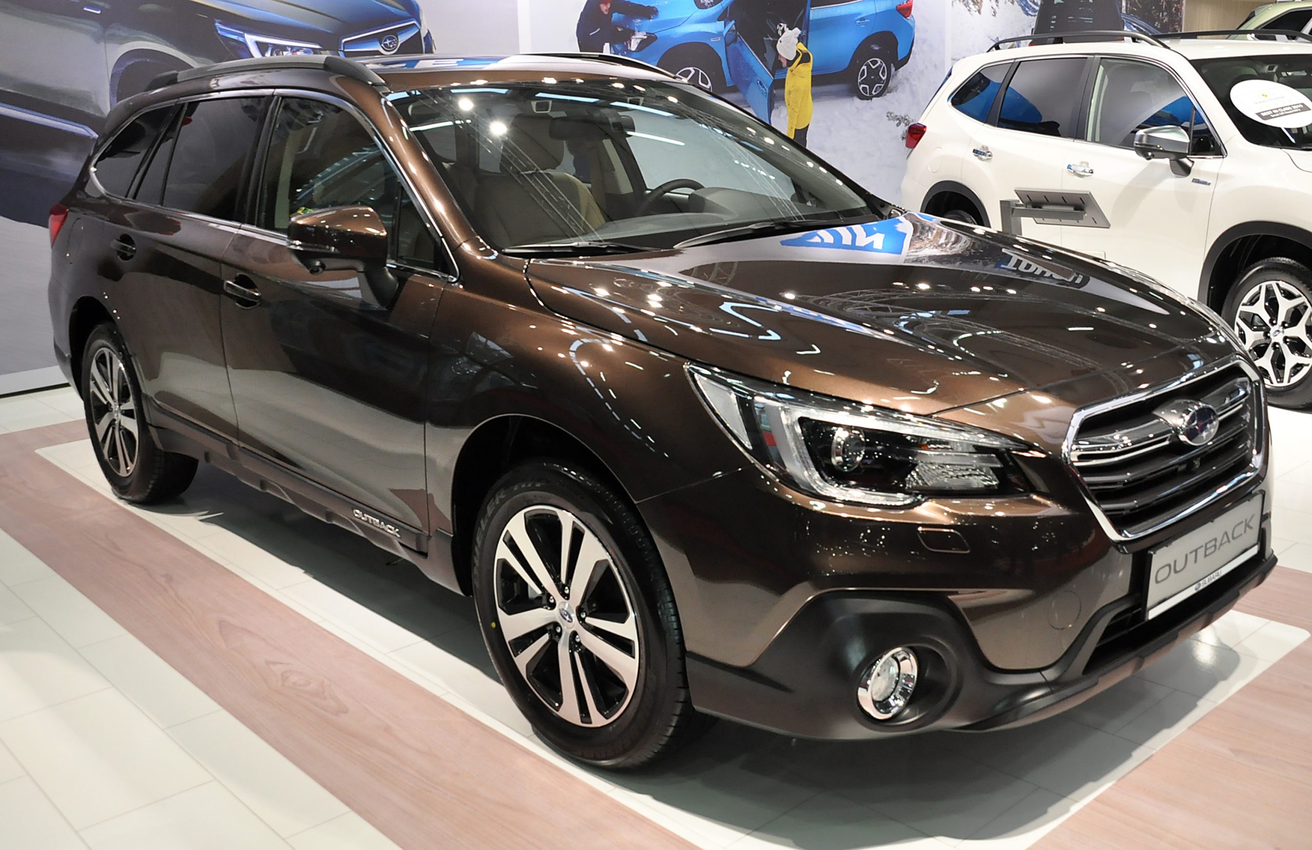 A brown Subaru Outback on display at an auto show