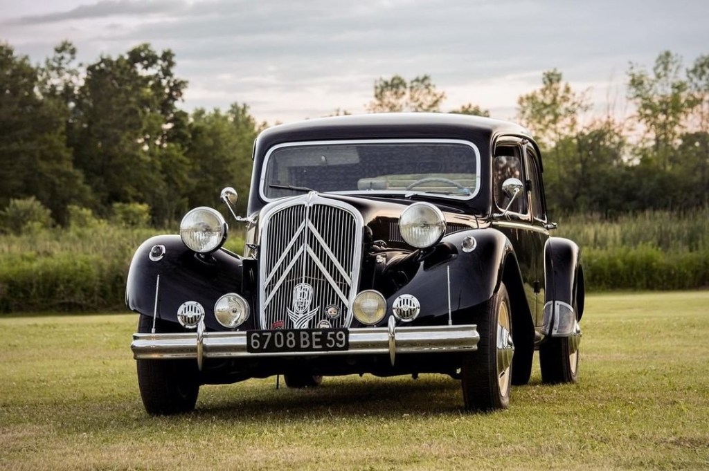 A black Citroen Traction Avant 15/6 parked in a grassy field