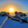 The Electraline Lakester electric vehicle is in the foreground of the Bonneville Salt Flats, with the sunrise in the distance.