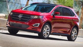 A red 2015 Ford Edge parked by a glass building.