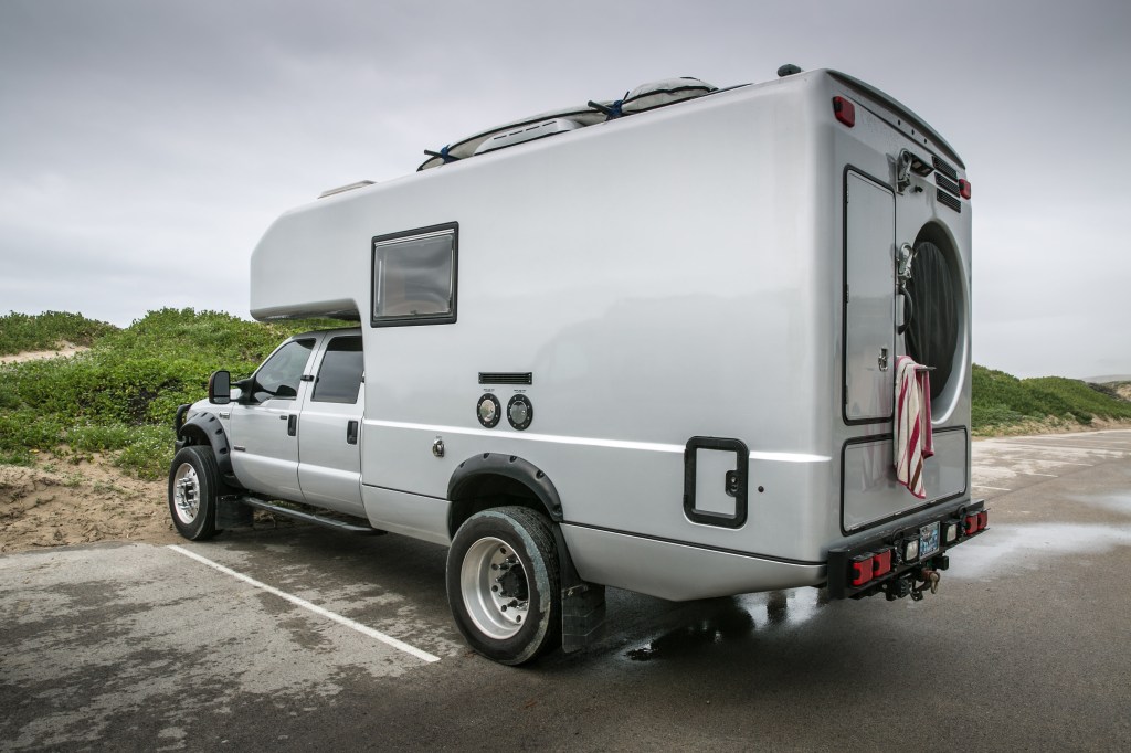 A custom Ford F-550 camper parked at a camp site