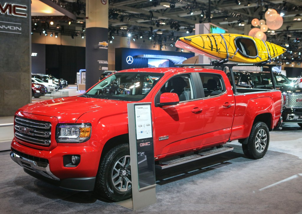 A red GMC Canyon on display at an auto show