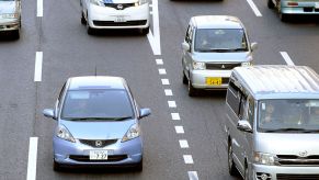 A Honda 'Fit' (L) is driven down a road in Tokyo on February 4, 2011. In January the Honda 'Fit' replaced Toyota's popular hybrid 'Prius' model as Japan's top selling car, a title that the Toyota model had held since May 2009, the Japan Automobile Dealers' Association said in a monthly report. AFP PHOTO / TOSHIFUMI KITAMURA (Photo credit should read TOSHIFUMI KITAMURA/AFP via Getty Images)