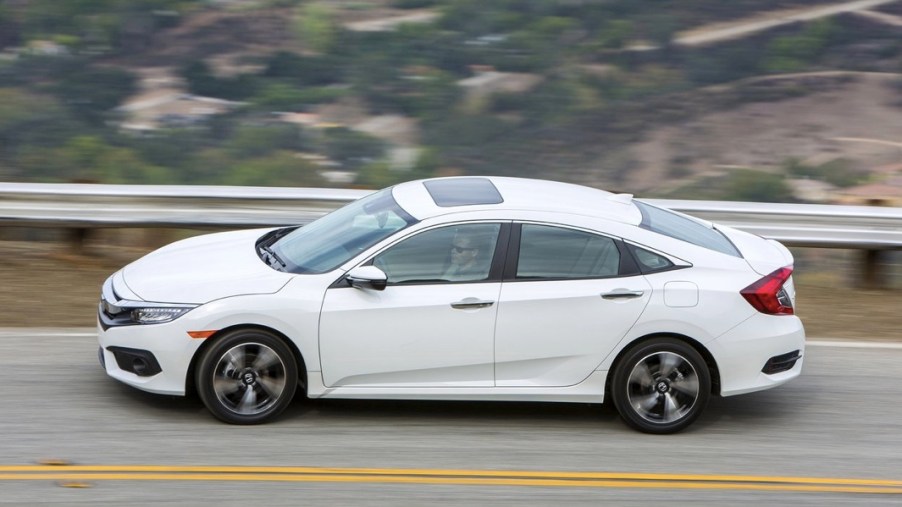 2016 Honda Civic side view from above as it drives on a scenic mountain road