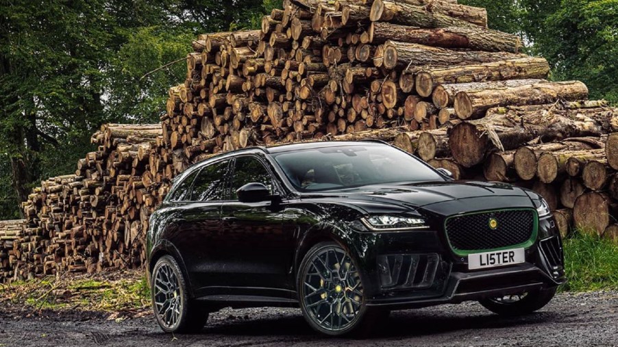 A black Lister Stealth in front of a pile of cut logs