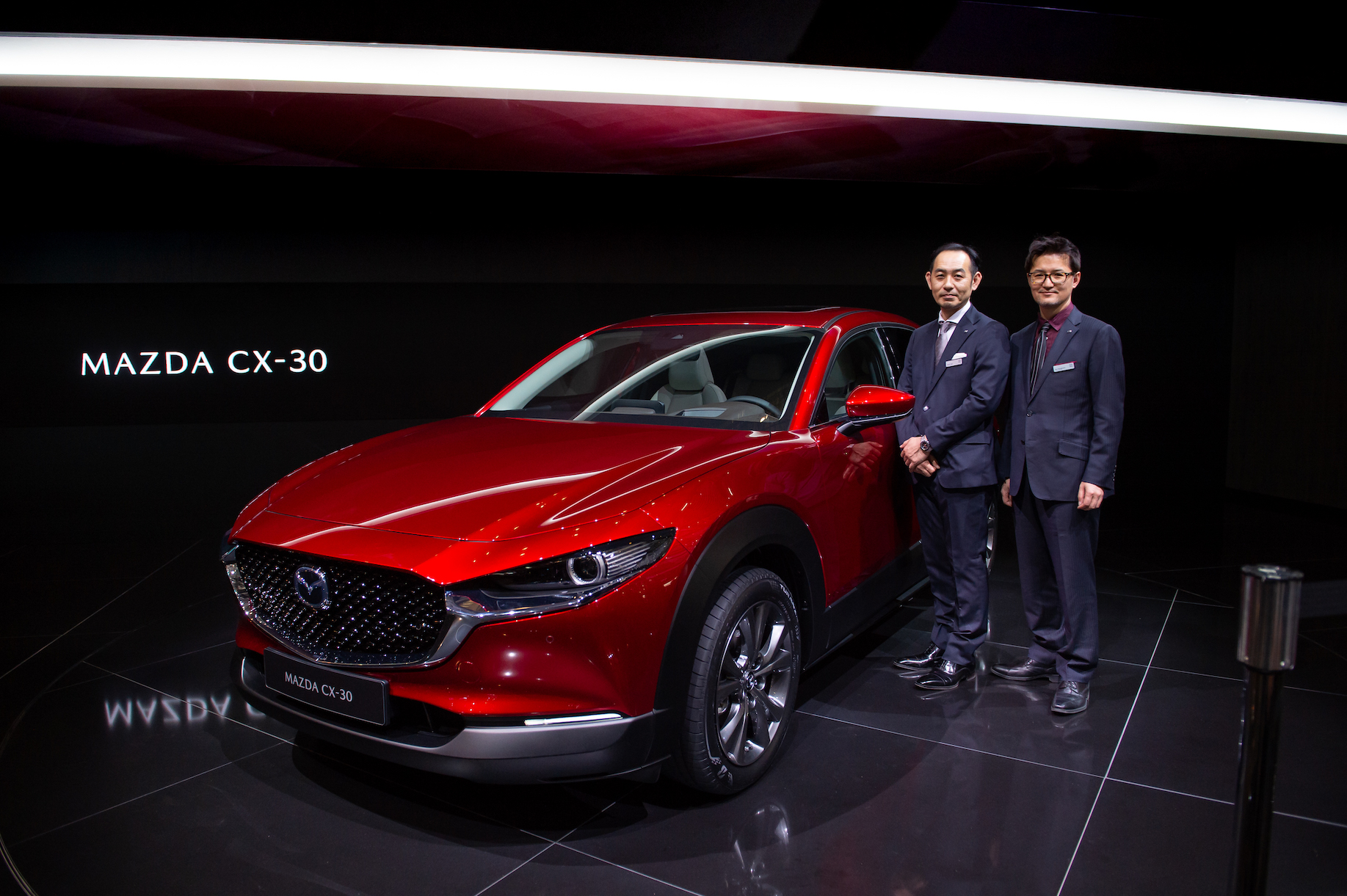 Chief Designer Ryo Yanagisawa (right) poses with Mazda CX-30 is displayed during the second press day at the 89th Geneva International Motor Show