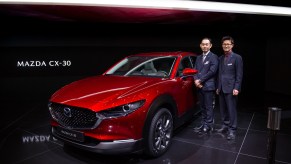 Chief Designer Ryo Yanagisawa (right) poses with Mazda CX-30 is displayed during the second press day at the 89th Geneva International Motor Show