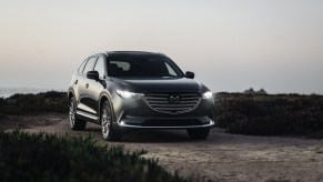 a gray 2020 Mazda CX-9 SUV driving on a gravel road in the countryside