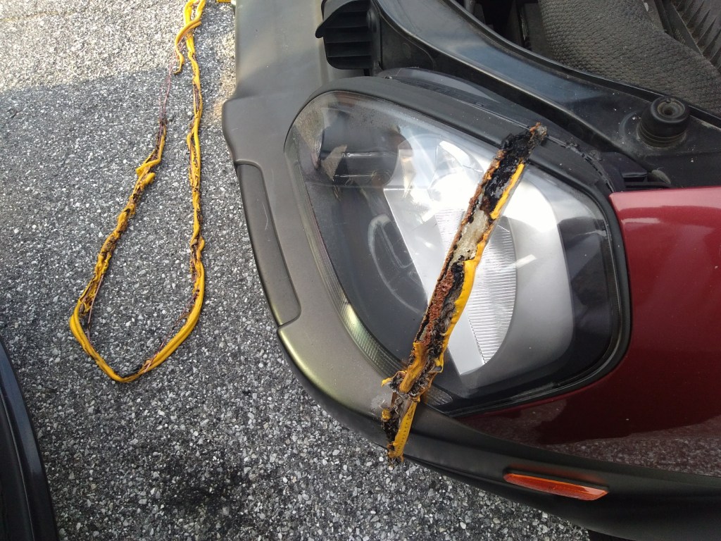 A headlight and bumper show damage after jumper cables were hooked up to a battery backwards to charge a car.