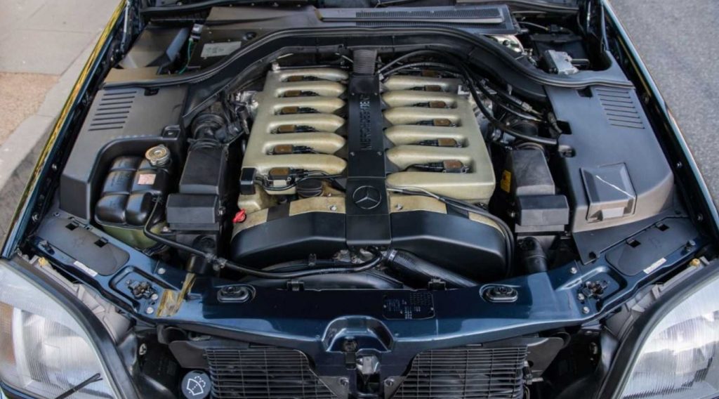 The open hood on a Mercedes reveals a V12.