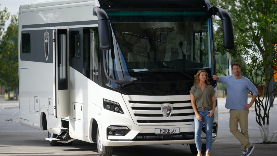 Two models are standing in front of the Morelo Palace 90 SE motorhome RV
