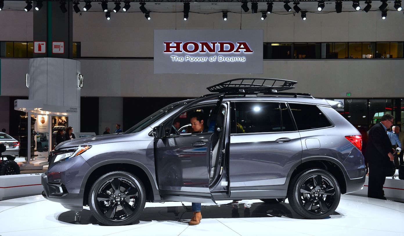 A woman checks out the drivers side of a 2019 Honda Passport AWD Elite on display at AutoMobility LA