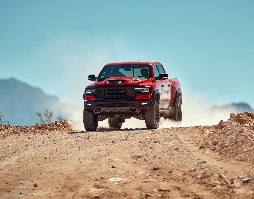 a red Ram 1500 TRX at speed on a dusty desert trail
