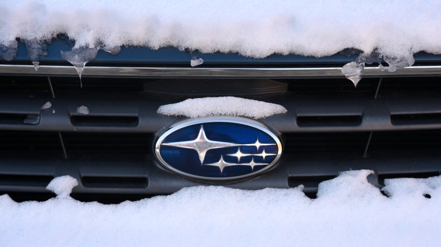 The Subaru logo attached to the grill of a snow-covered Subaru Outback in New Mexico.