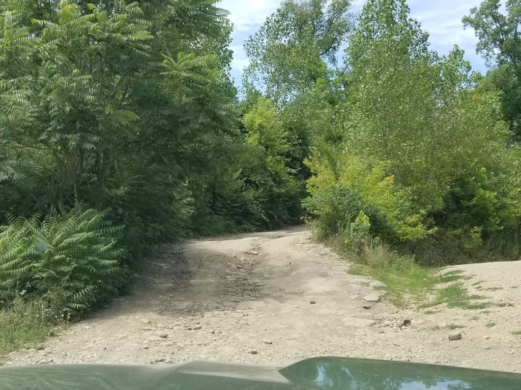 The tree-lined rocky uphill start of The Cliffs Insane Terrain Off-Road Park's Trail 1